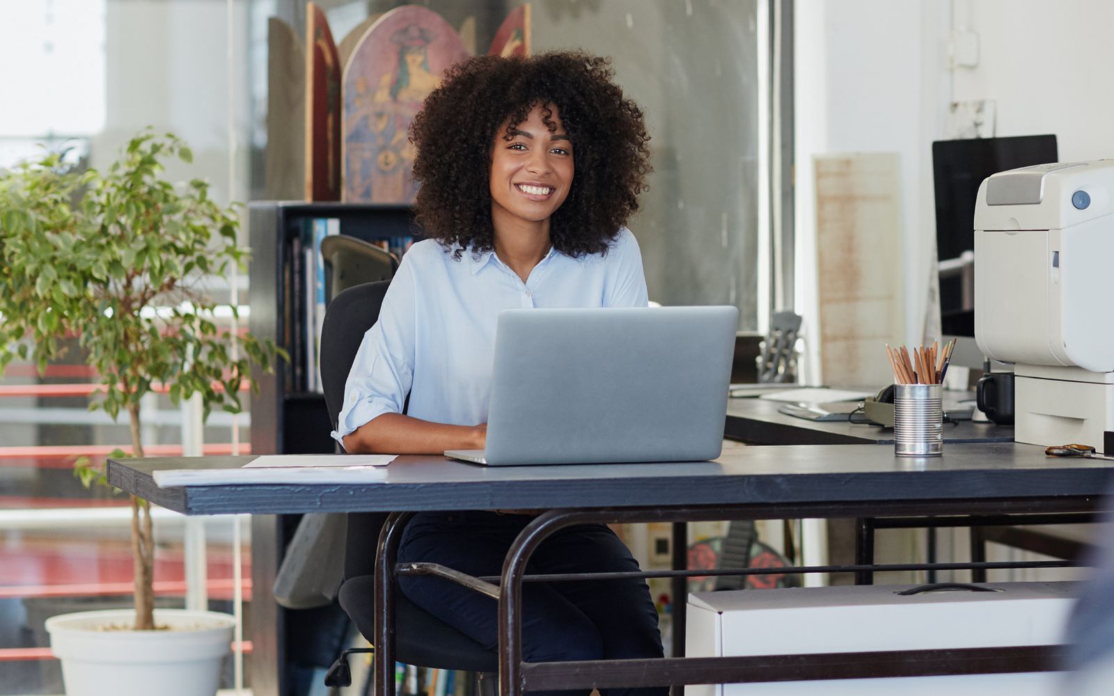 Femme de couleur à son bureau avec un ordinateur